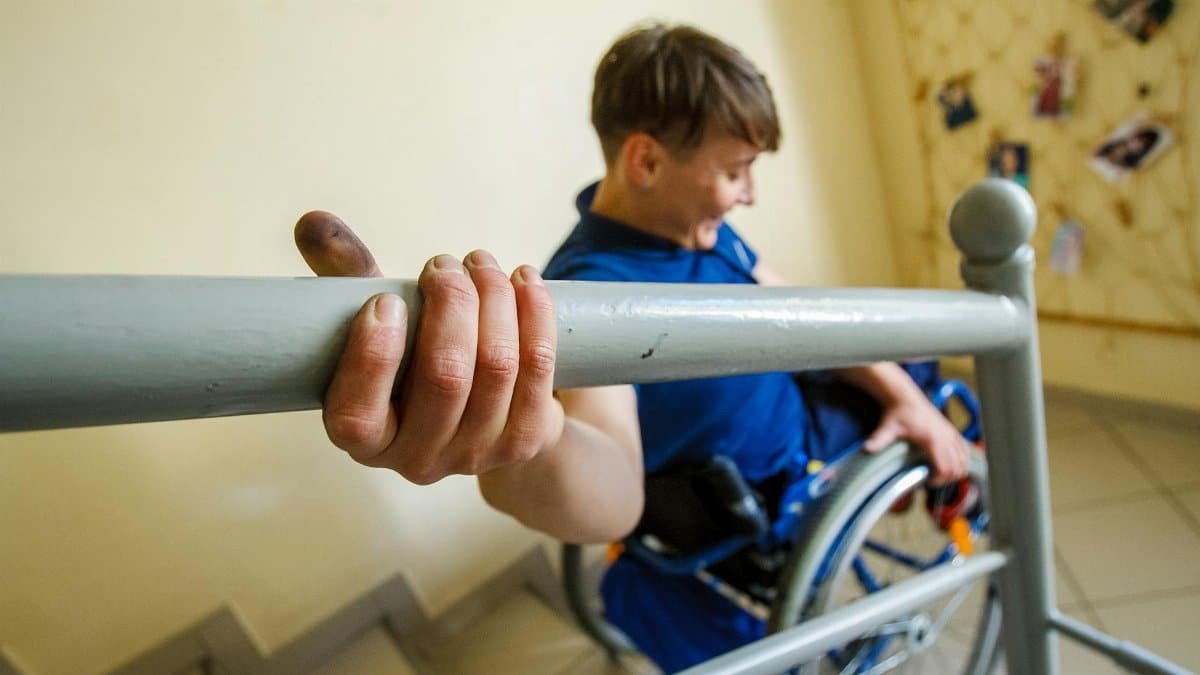 Woman in wheelchair confidently navigating stairs, exhibiting strength and independence.