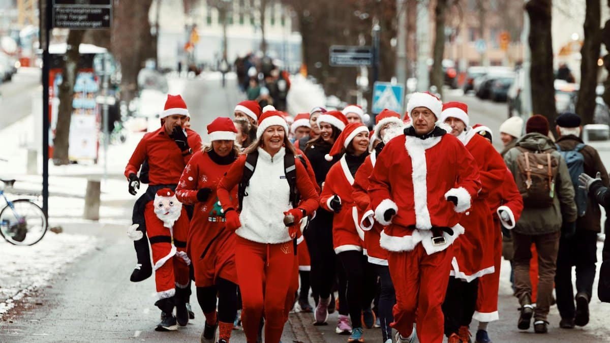 A group of people in Santa costumes enjoys a festive run through snowy Gothenburg, Sweden.