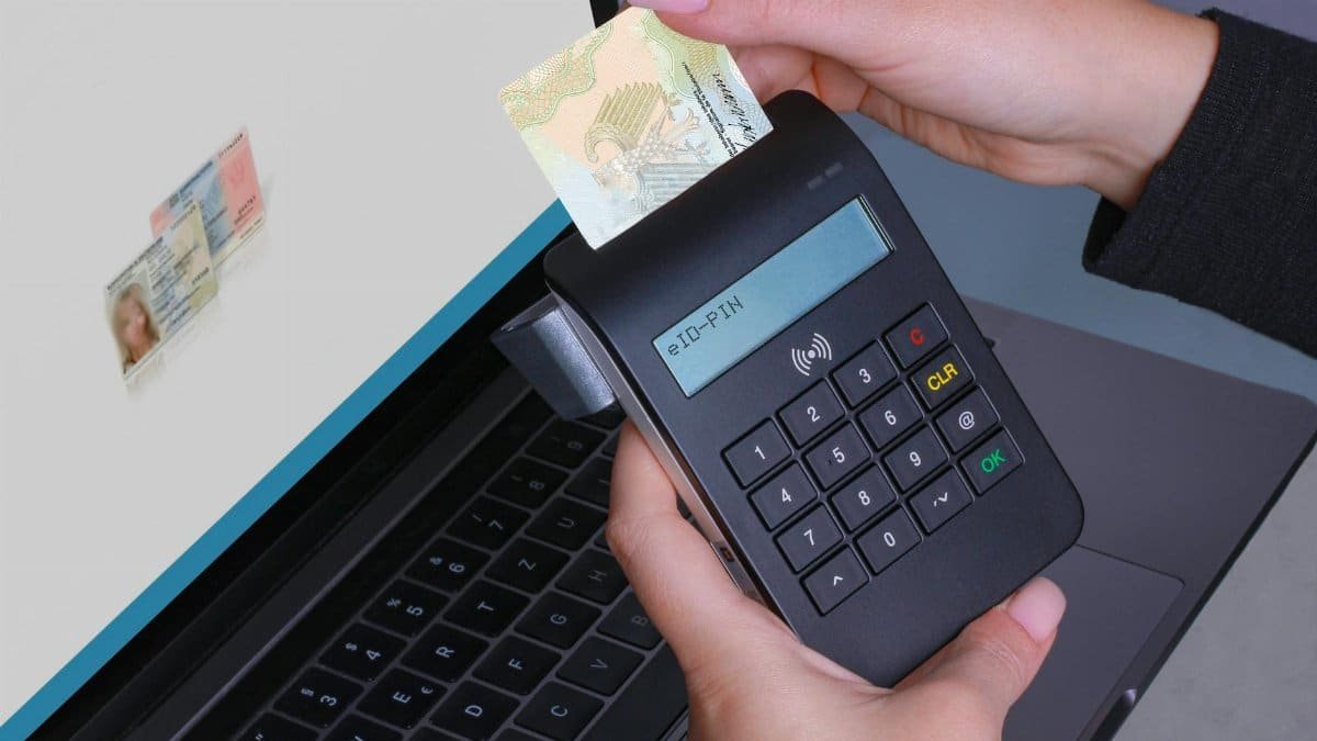 Person using contactless device for ID payment verification on a laptop.