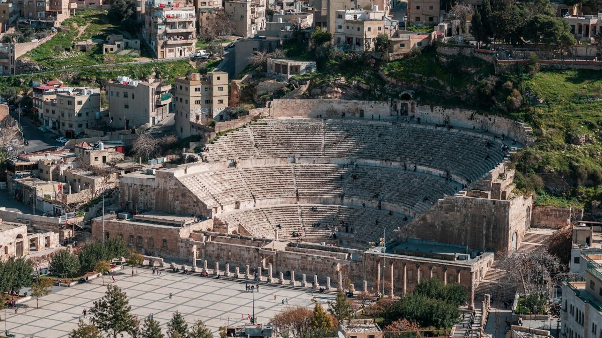 Explore the ancient Roman Amphitheater in Amman, Jordan, through this stunning aerial perspective.