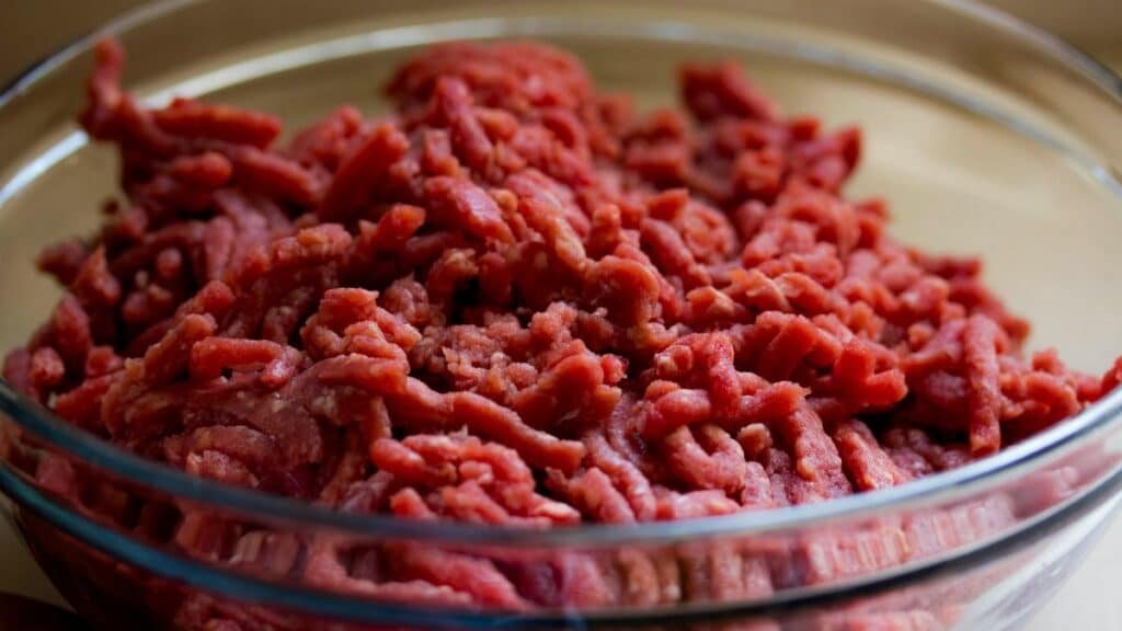 High-quality image of fresh ground beef in a glass bowl, ideal for culinary and food-related themes.