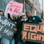 A diverse group of protesters holding signs advocating for justice and equal rights.