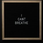 Top view of phrase I Cant Breath on small black signboard with light beige thin frame on black background