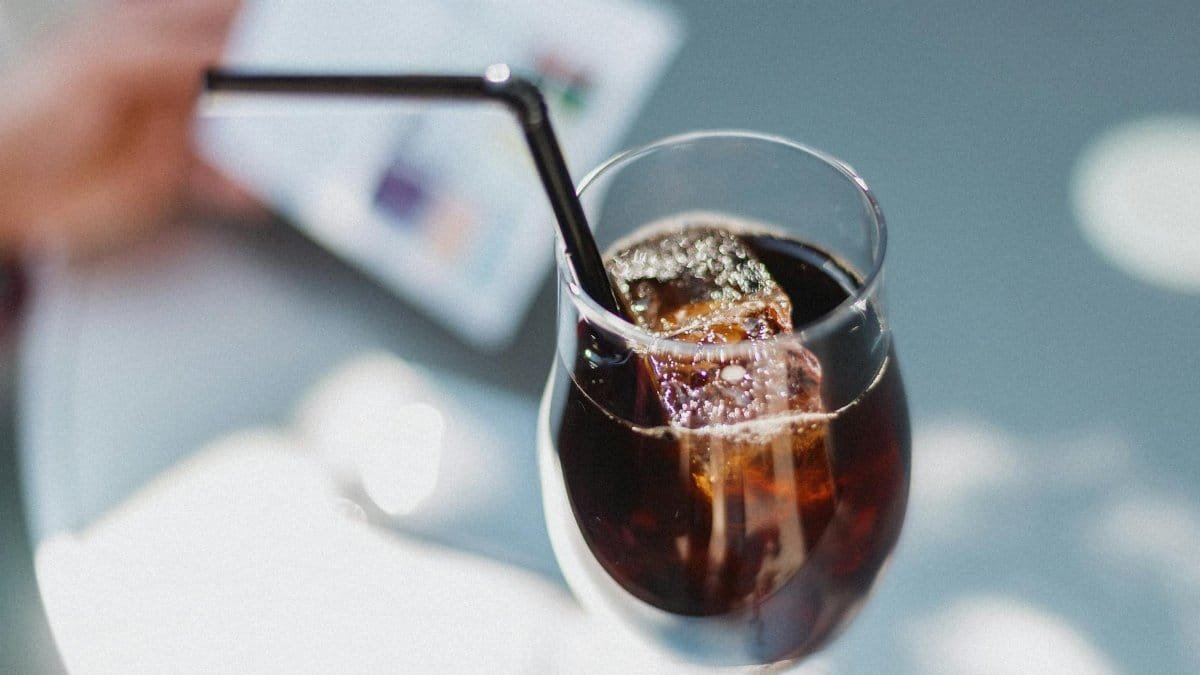 Close-up of a glass of iced coffee with a straw, capturing the refreshing vibe of a café setting.