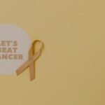 Minimalist design featuring a ribbon and 'Let's Beat Cancer' message for cancer awareness.