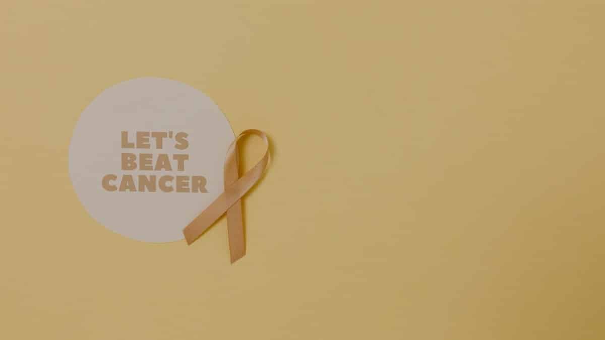 Minimalist design featuring a ribbon and 'Let's Beat Cancer' message for cancer awareness.