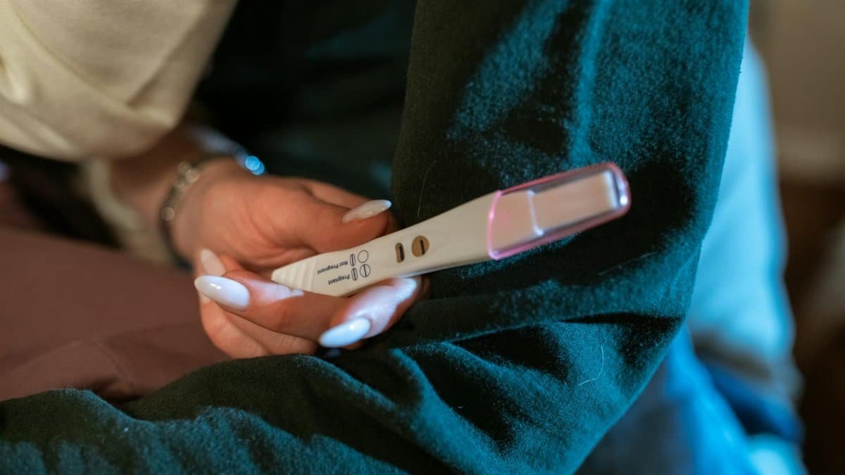 A woman's hand holding a positive pregnancy test, symbolizing hope and new beginnings.