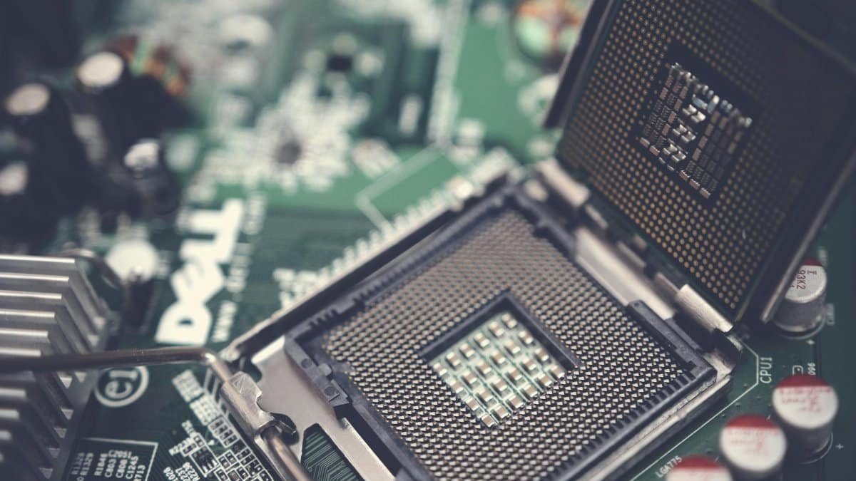 Detailed view of a CPU socket on a green motherboard, showcasing microprocessor technology.