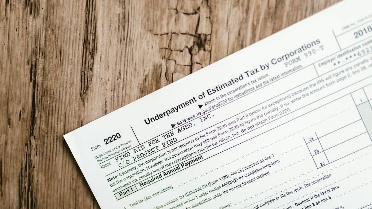 Close-up of a corporate tax form on a textured wooden surface, highlighting document details.