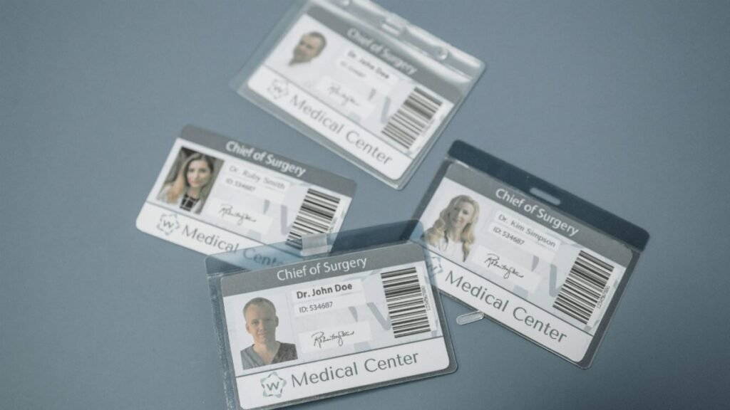 High-angle view of medical ID badges for chief surgeons on a gray surface.