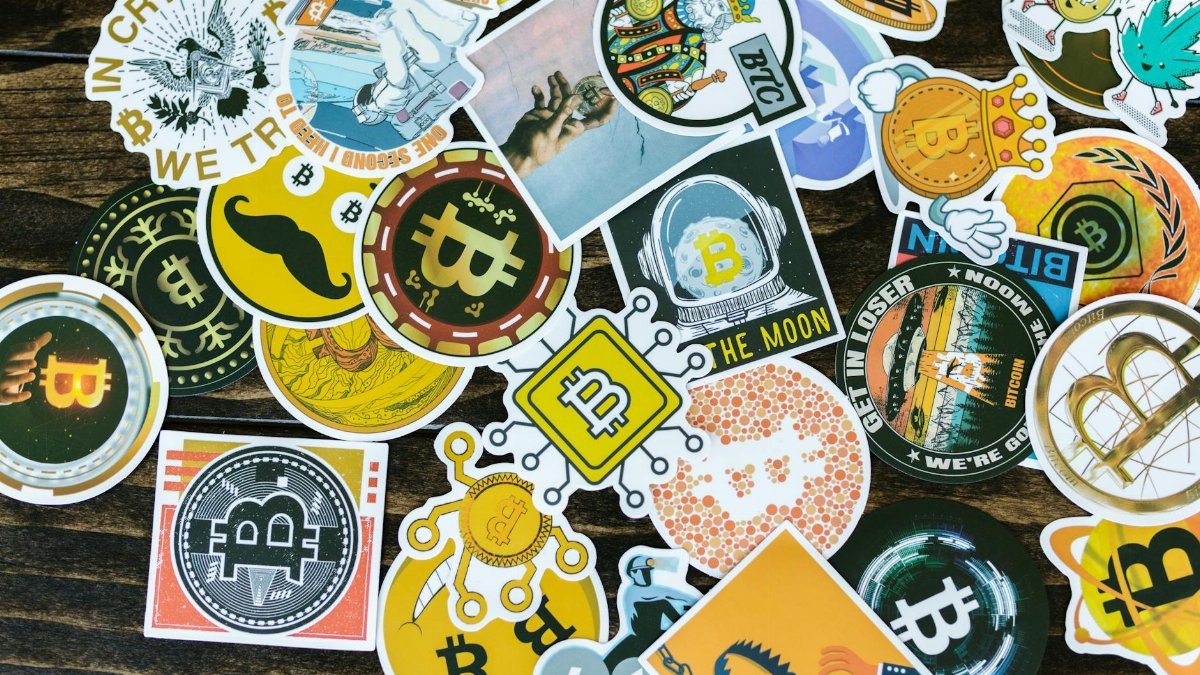 Colorful collection of Bitcoin-themed stickers on a wooden background, ideal for cryptocurrency concepts.