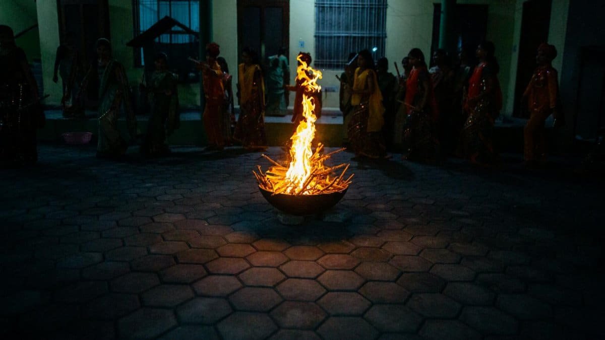A cultural night gathering featuring a central bonfire surrounded by people in traditional attire.