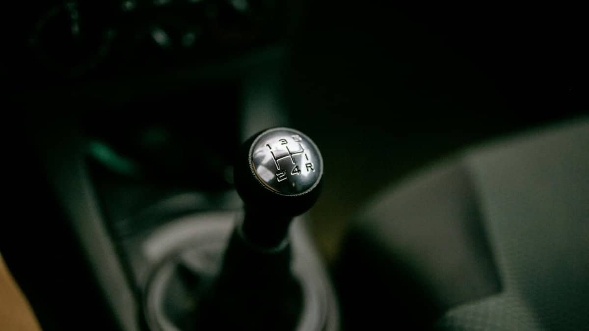 Detailed view of a manual gear shifter inside a vehicle, with a focus on the gear shift knob.