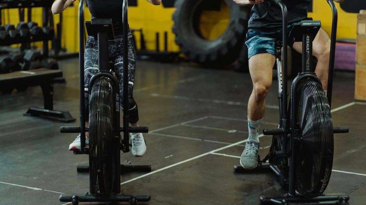 Two people exercising on stationary bikes at a modern gym.