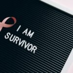Letter board with pink ribbon symbolizing breast cancer survival.