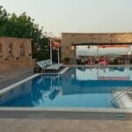 A serene swimming pool at a resort showcasing luxury and relaxation amidst natural surroundings.