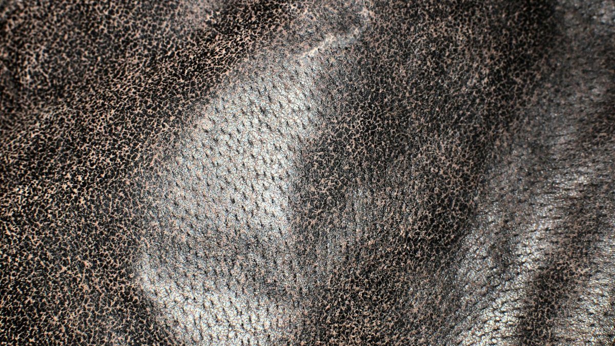 Full frame textured background of uneven natural leather fabric made of animal skin