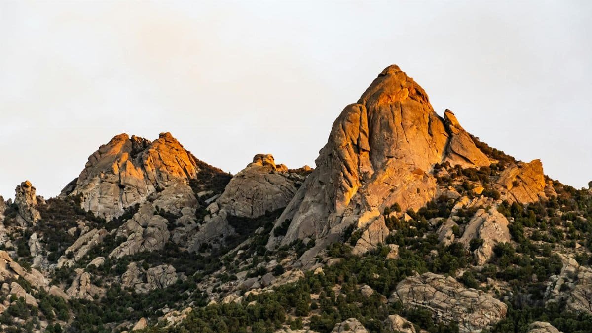 Captivating view of rugged mountain peaks illuminated by the warm glow of sunrise, showcasing nature's beauty.