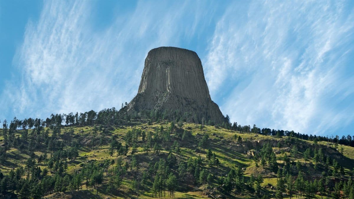 Stunning landscape of Devils Tower in Wyoming, showcasing its iconic rock formation against a clear blue sky.