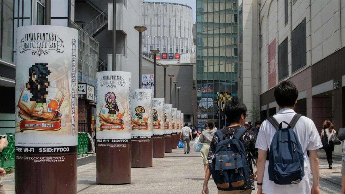 Bustling urban street in Chiyoda City, Tokyo with pedestrians and Final Fantasy ads.