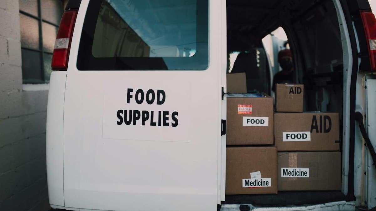 Van loaded with aid supplies and food boxes for charity distribution.