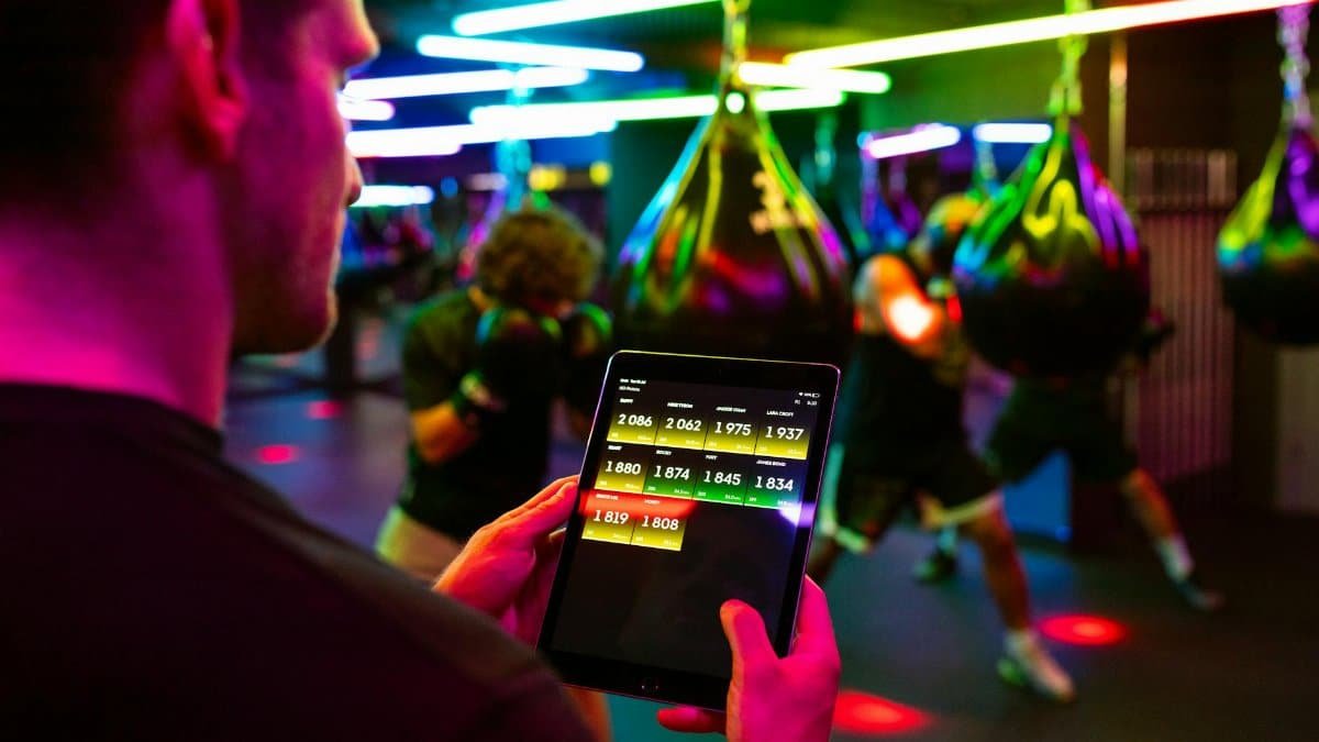Fitness training in a modern gym with technology for tracking performance on a tablet.