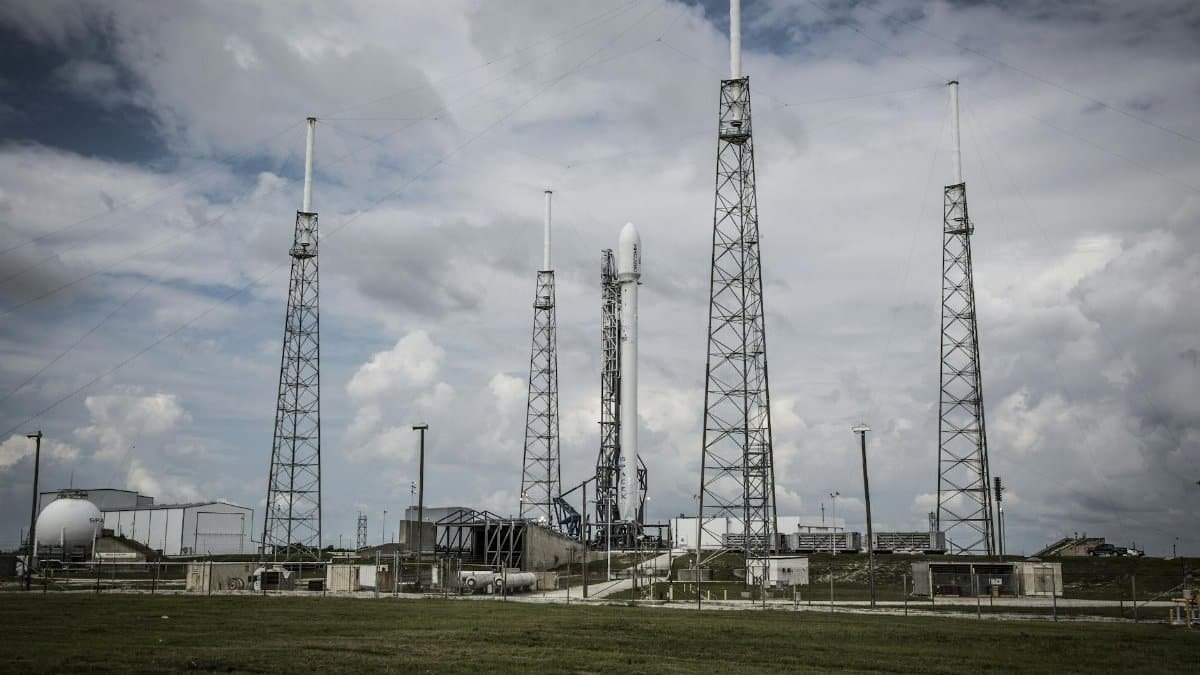 Industrial rocket launch pad with tall towers under a cloudy sky, perfect for technology and energy themes.