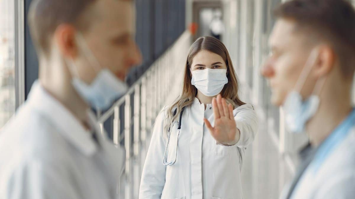 Doctors in masks demonstrating healthcare safety and teamwork indoors.