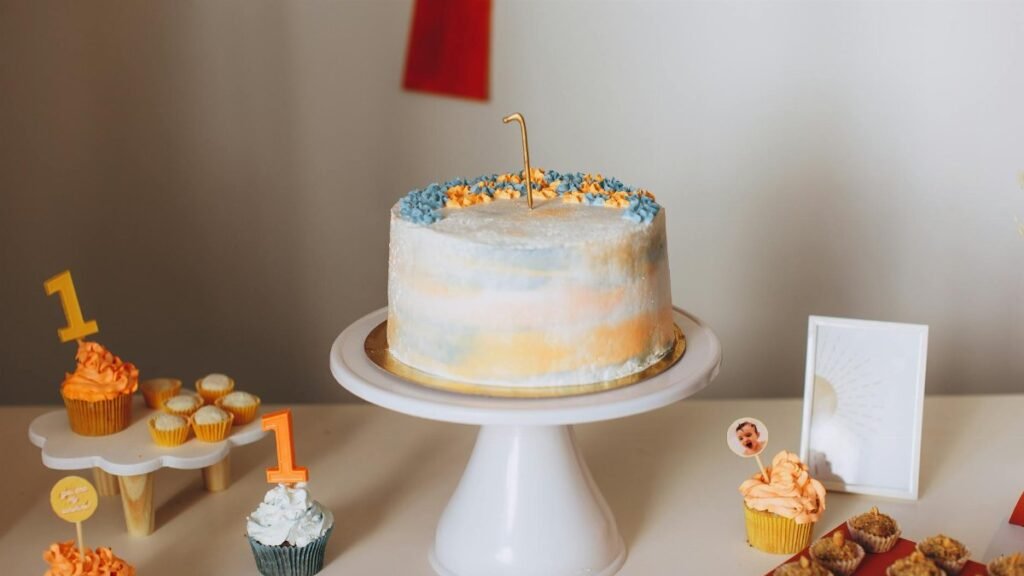 A beautifully decorated cake with cupcakes for a first birthday celebration.