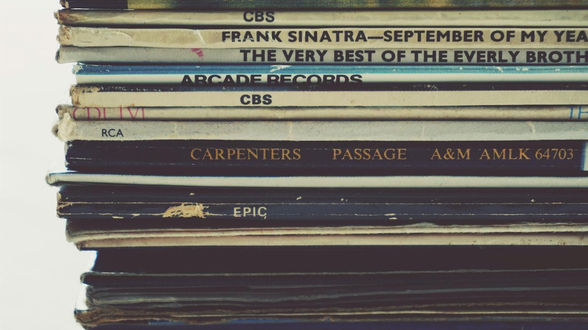 Close-up view of a stack of vintage vinyl records showcasing album spines.