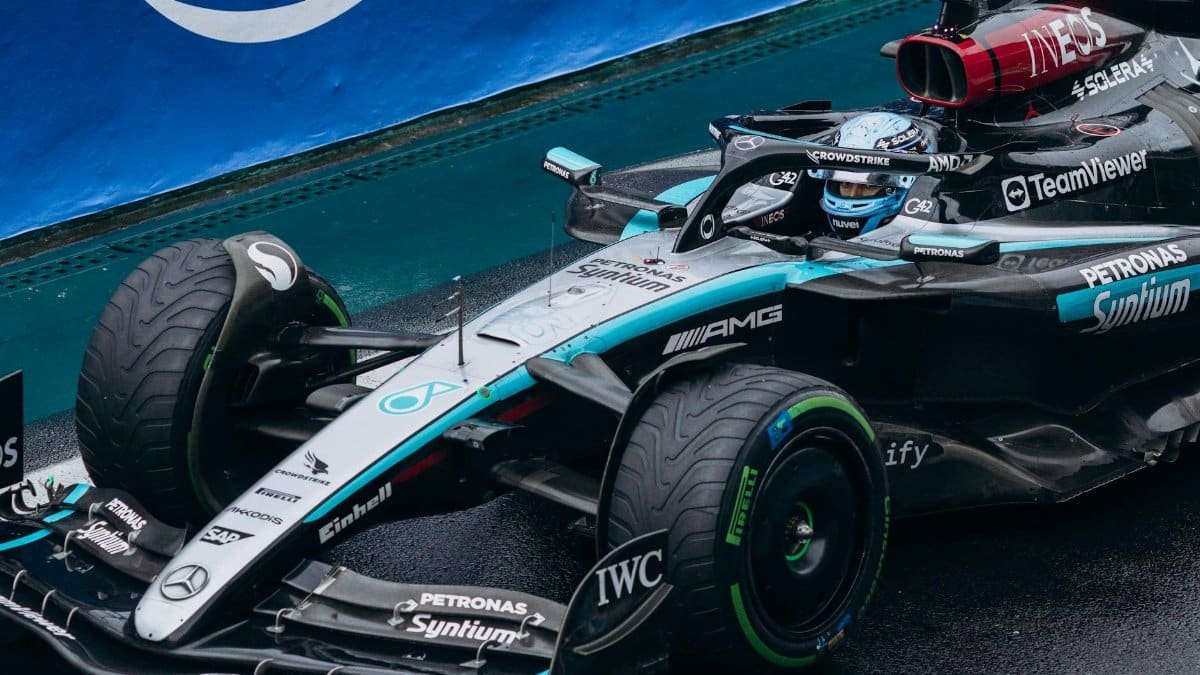 Close-up of a sleek race car navigating a wet track, showcasing its speed and design.