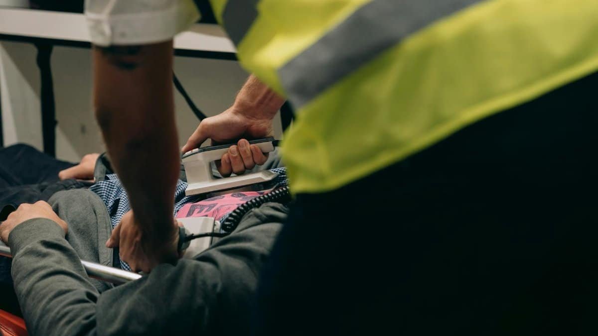 Paramedics provide urgent care to a patient on a stretcher during an emergency situation.