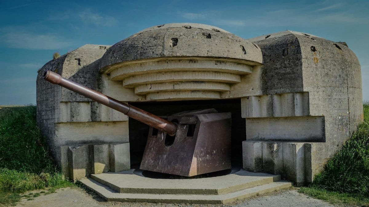 Photograph of a World War II bunker with a cannon in Normandy, France.