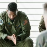 A soldier dressed in uniform sits pensively during a counseling session, embodying themes of mental health and support.