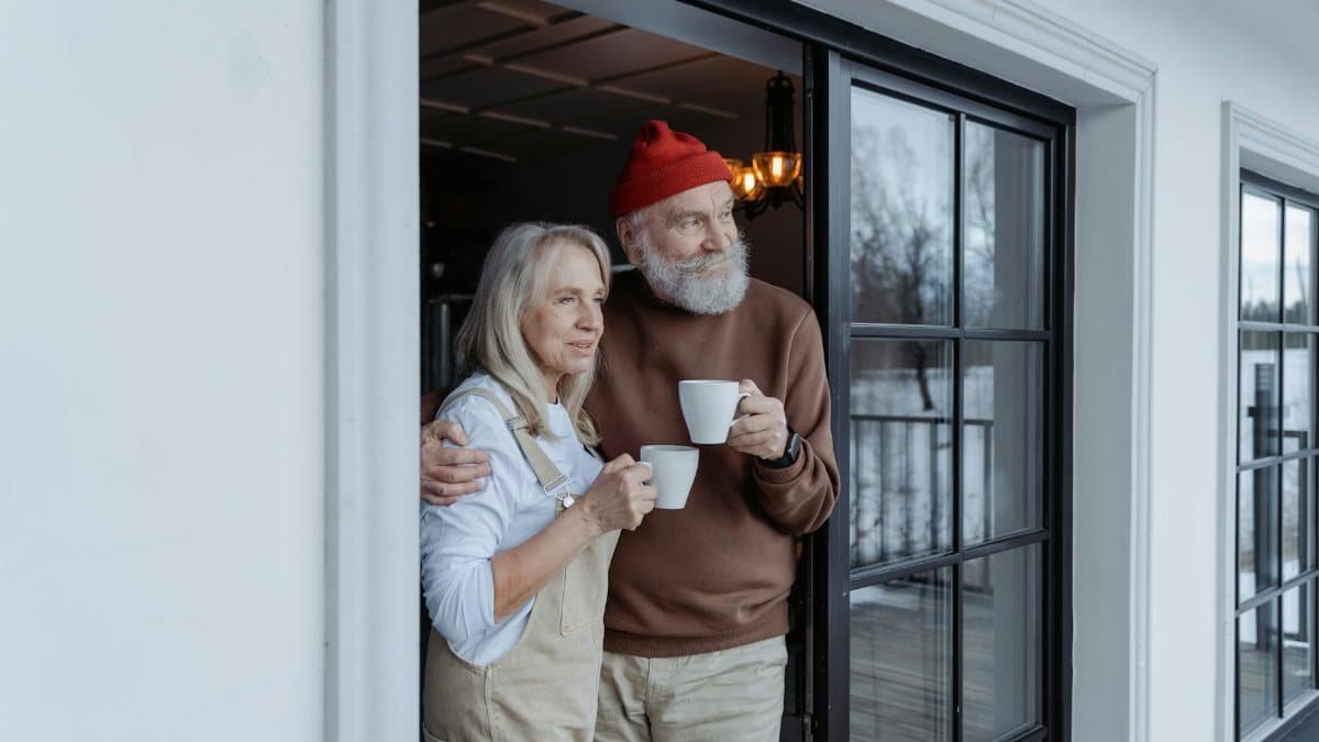 Happy senior couple enjoying coffee together at home, embracing love and warmth.
