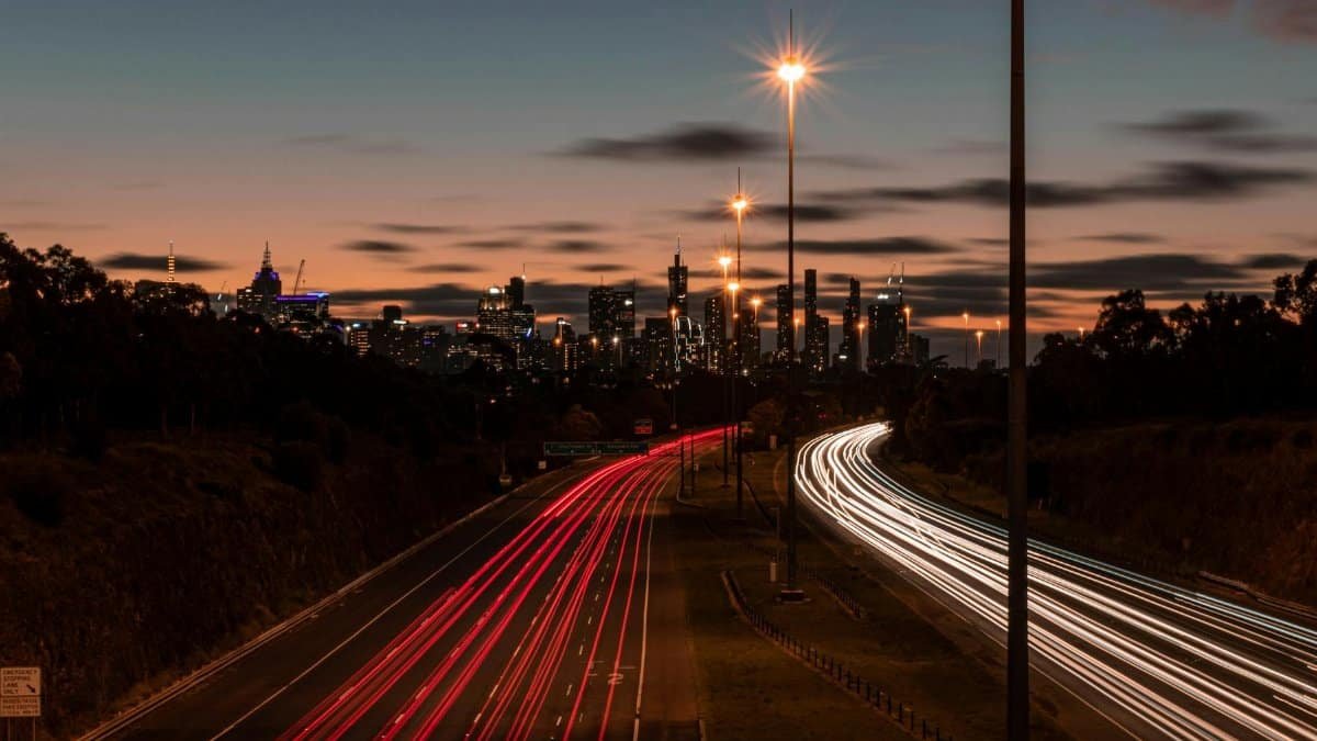 A stunning view of Melbourne's skyline with long exposure light trails from highway traffic.