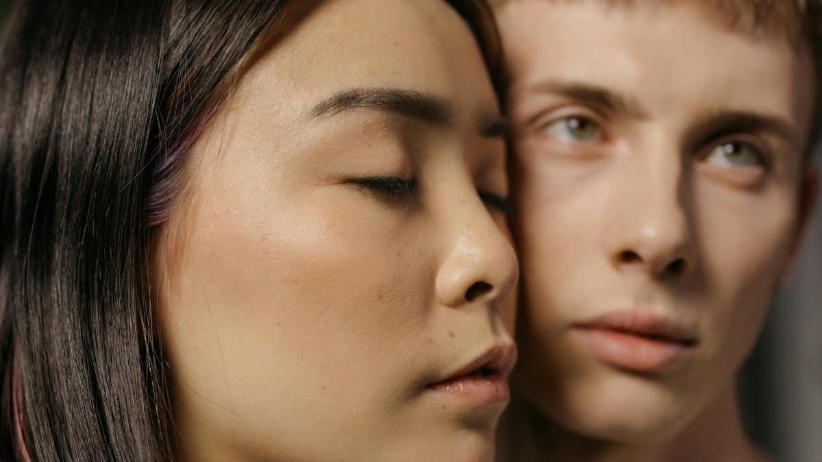 Close-up portrait capturing the intimacy and connection between a couple in warm, soft light.