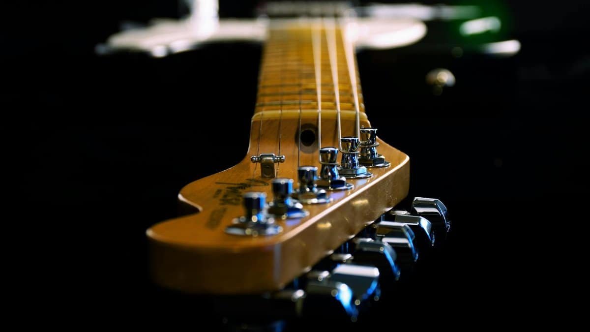 Artistic close-up of an electric guitar showing strings and tuners, highlighting depth and craftsmanship.