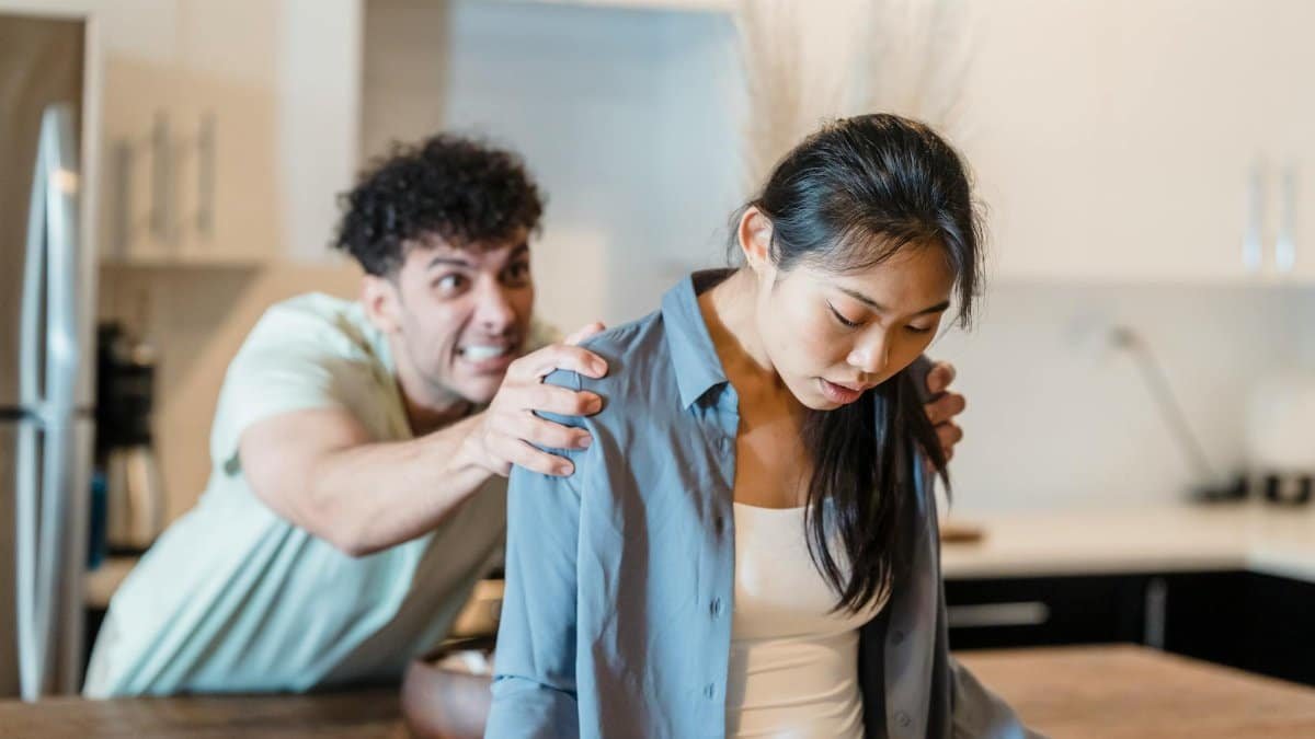 A couple experiencing emotions and tension in a modern kitchen setting.