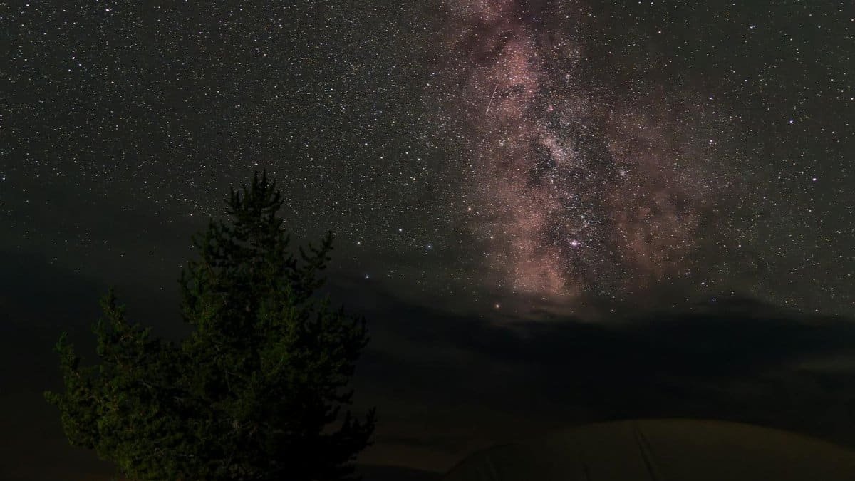 Camping under the stunning Milky Way in Wyoming's wilderness. Perfect for adventure seekers.