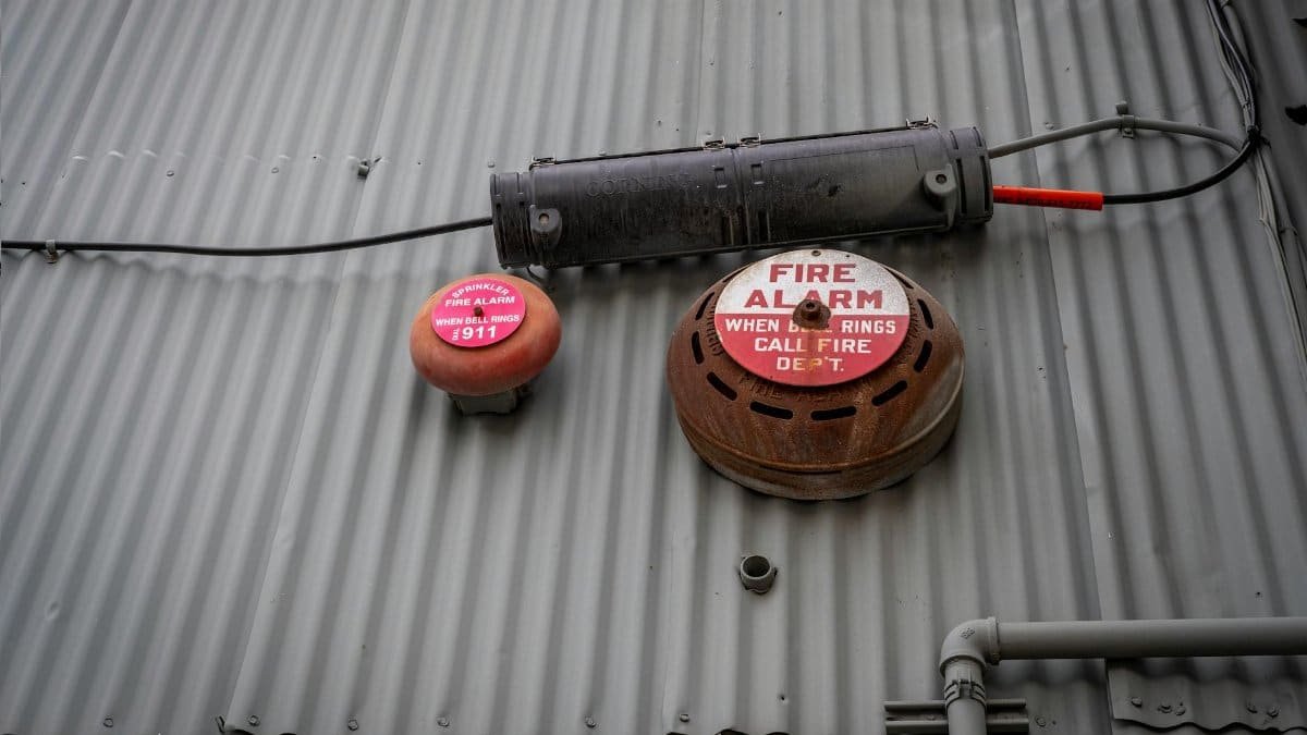 An industrial fire alarm system mounted on a corrugated metal wall for safety and security.