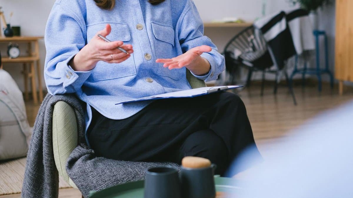 A therapist consults with a client in a contemporary office, focusing on mental health.