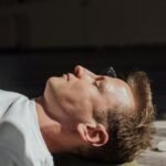 Man meditating indoors with crystals, focusing on relaxation and healing energy.