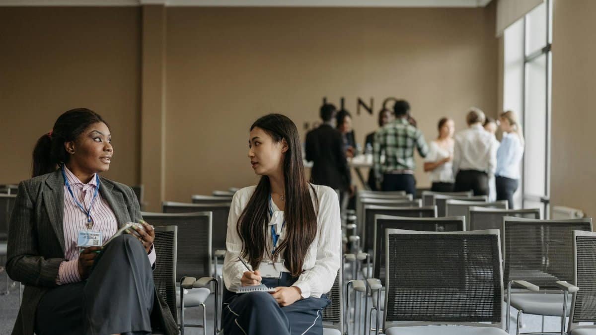 Two businesswomen in conversation during a break at a conference.