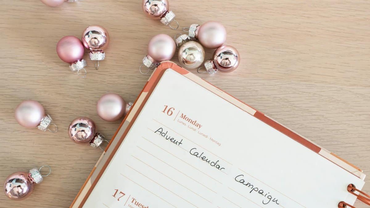 Close-up of a planner with Advent campaign notes and pink baubles.