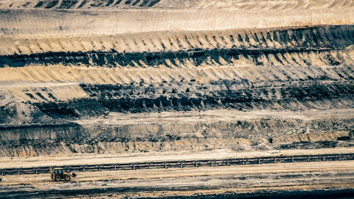 Aerial view of an open-pit mine with excavator in Inden, Germany.