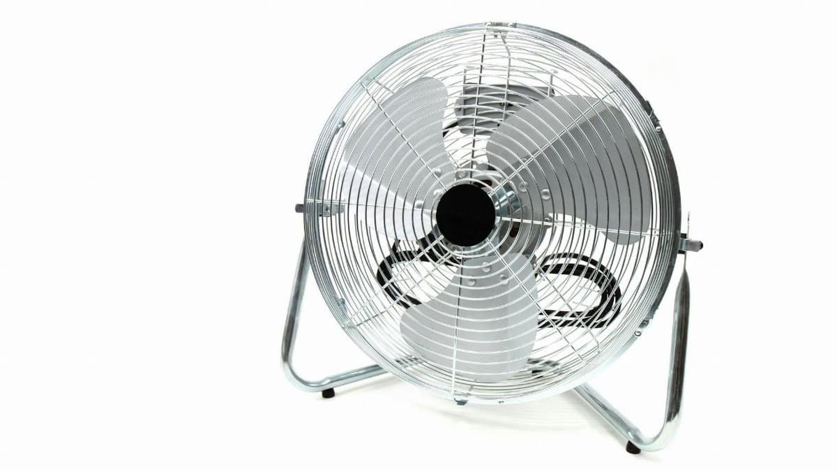 Sleek stainless steel industrial floor fan with metal blades isolated on white.