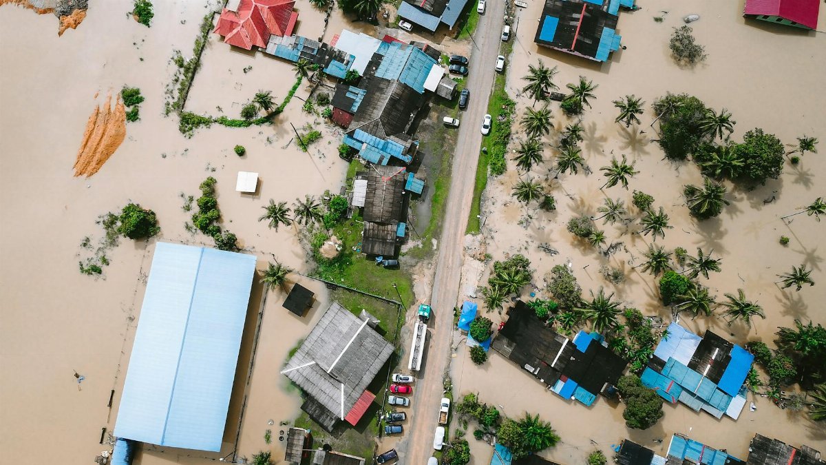 Drone view of a residential area in Kijal, Malaysia, showing extensive flooding and submerged buildings.