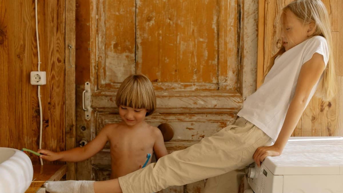 Two cheerful children having fun together indoors, showcasing sibling bonding and playful moments.