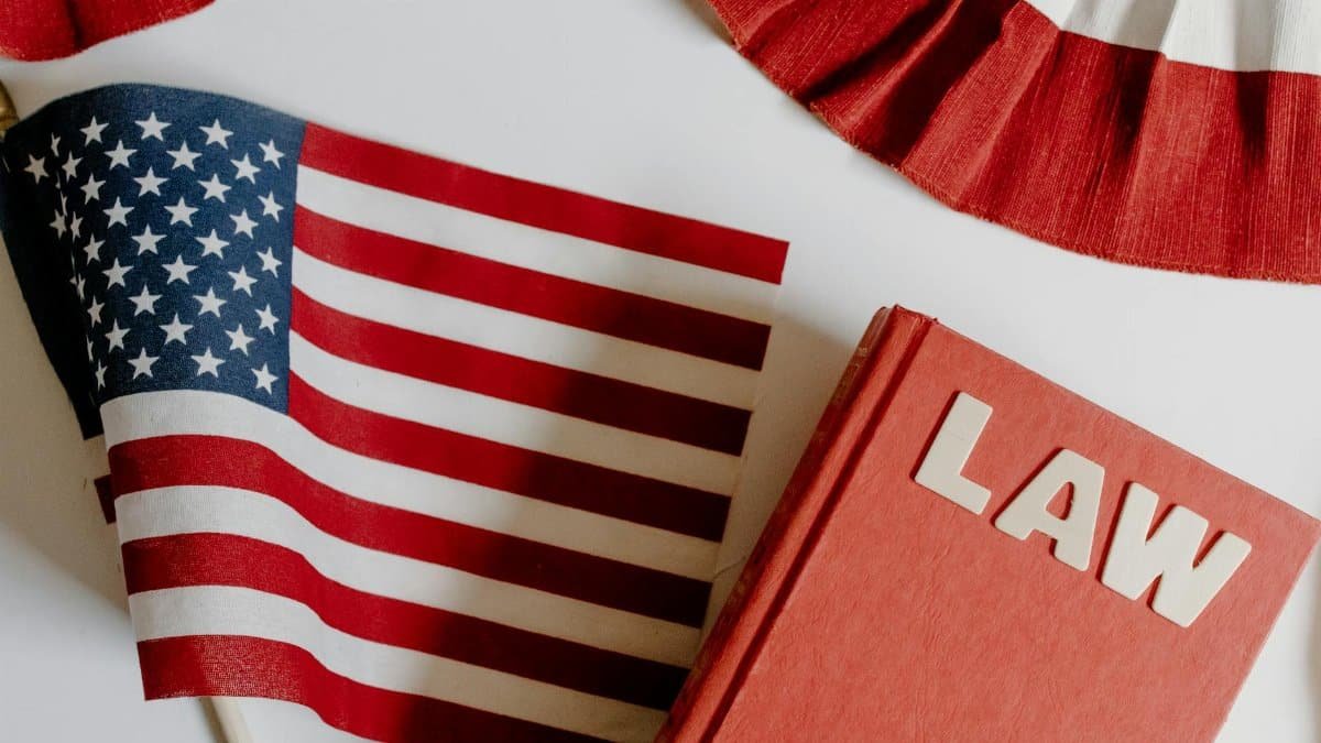 Patriotic scene with American flag and law book on a white background, symbolizing freedom and democracy.